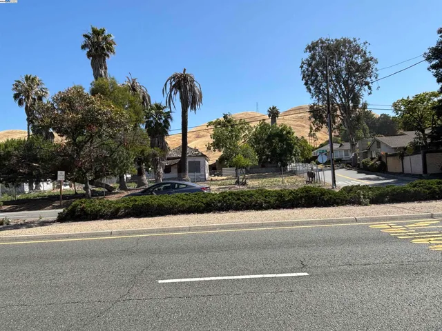 a front view of a house with a yard and palm trees