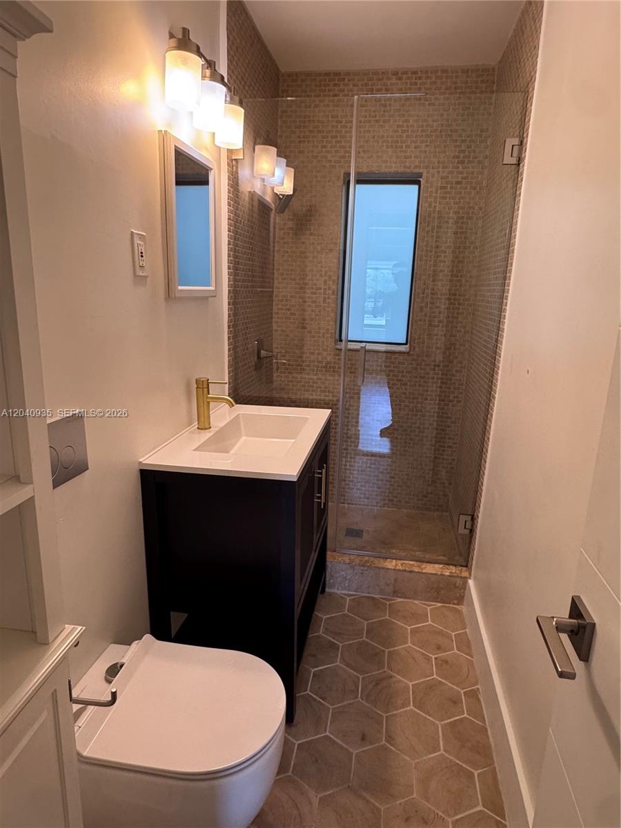 375 Southwest 32nd Road Miami, FL 33129 - Photo 37 of 44 a bathroom with a toilet sink and mirror