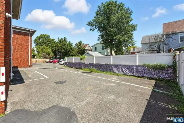 a view of a street with a building and trees in the background
