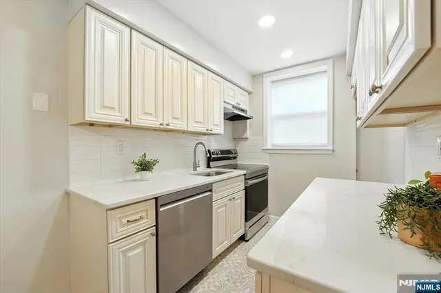 a kitchen with granite countertop white cabinets and white appliances