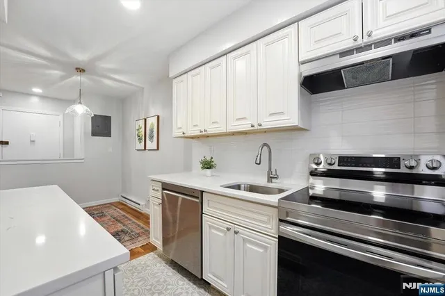a kitchen with stainless steel appliances white cabinets and a sink