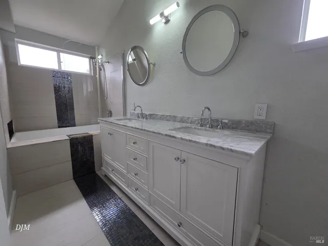 a bathroom with a double vanity sink and a mirror
