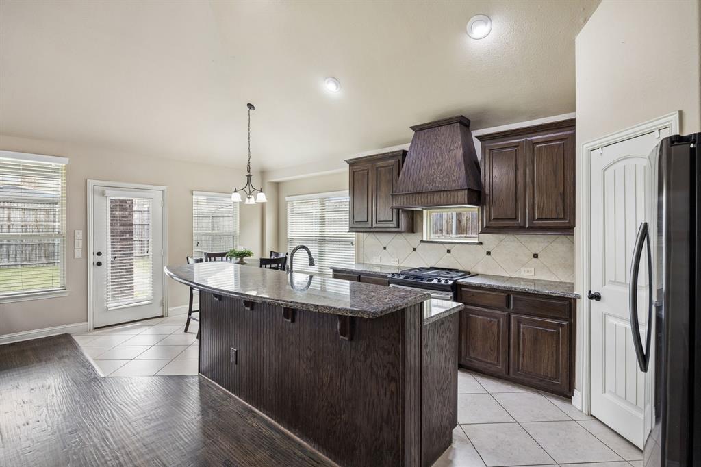 1014 Dunhill Lane Forney, TX 75126 - Photo 10 of 38 Kitchen with island showing cabinet space and lots of prep space on the granite counter tops.
