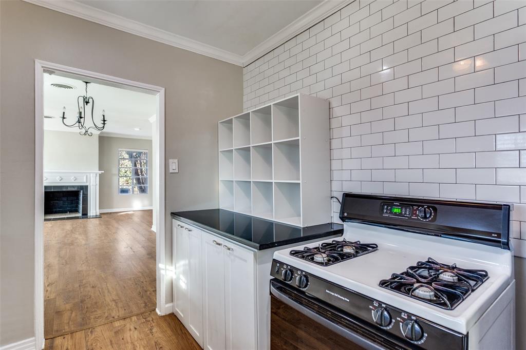 4045 Carolyn Road Fort Worth, TX 76109 - Photo 12 of 28 a kitchen with a stove and a fireplace with wooden floor