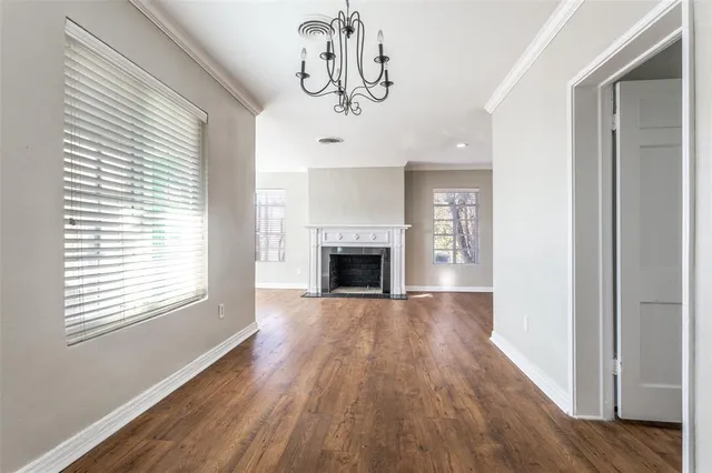 a view of a livingroom with wooden floor a fireplace and windows