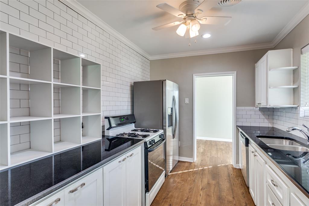 4045 Carolyn Road Fort Worth, TX 76109 - Photo 10 of 28 a kitchen with stainless steel appliances kitchen island granite countertop a stove and a refrigerator