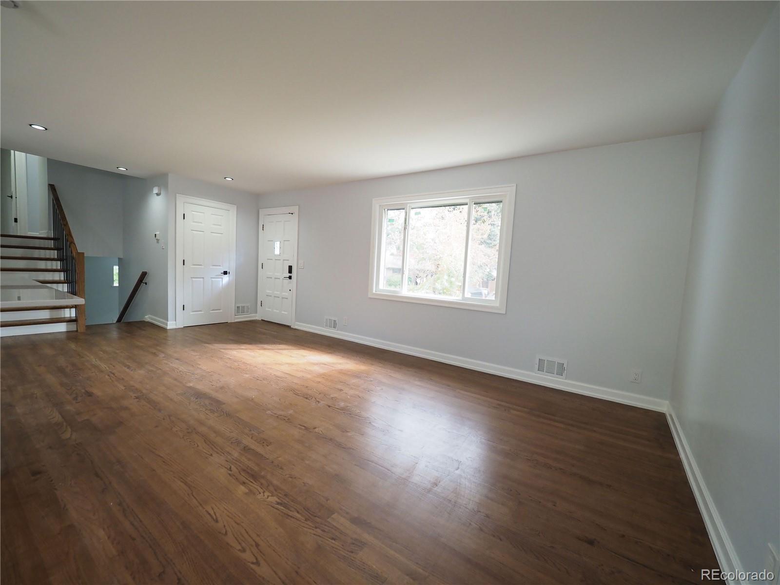6751 South Downing Circle West Centennial, CO 80122 - Photo 8 of 34 an empty room with wooden floor and windows