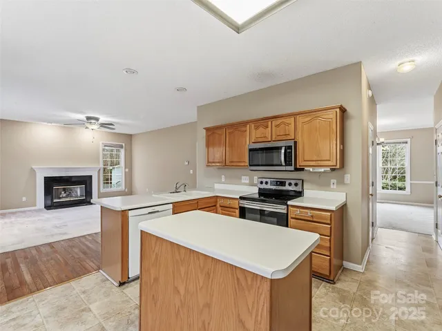 a view of a kitchen with granite countertop a sink and a stove top oven