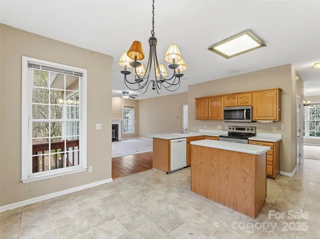 a view of a hallway to a livingroom with wooden floor and stairs