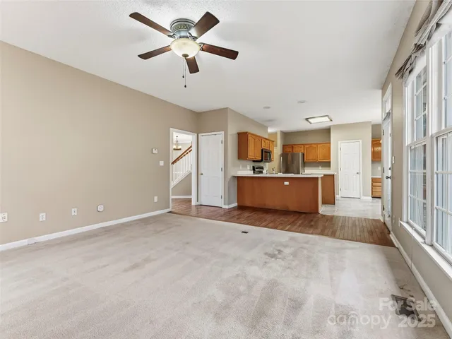 an empty room with windows and fireplace
