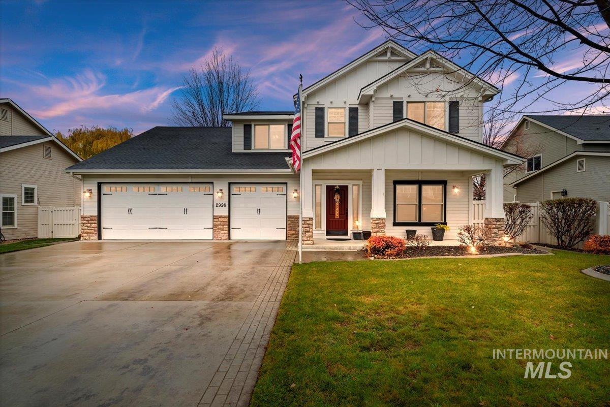 Craftsman inspired home with board and batten siding, stone siding, a porch, and concrete driveway