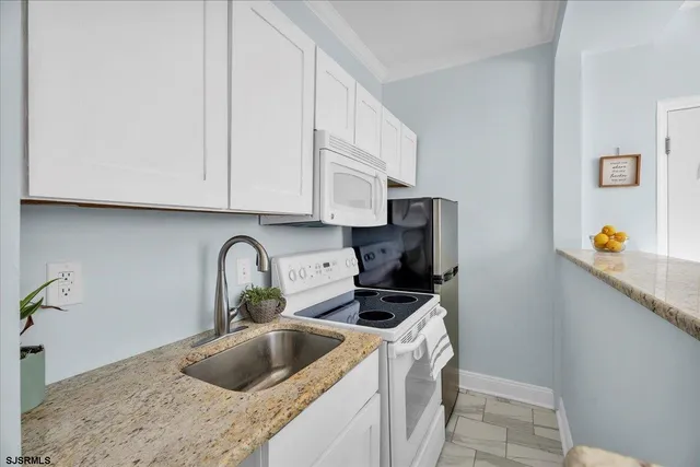 a kitchen with stainless steel appliances granite countertop a sink and a white cabinets