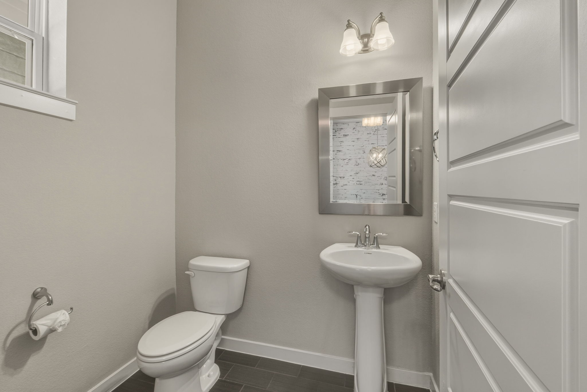 3919 Vaughan Street Austin, TX 78723 - Photo 9 of 40 A compact and clean powder room features a pedestal sink and modern lighting.