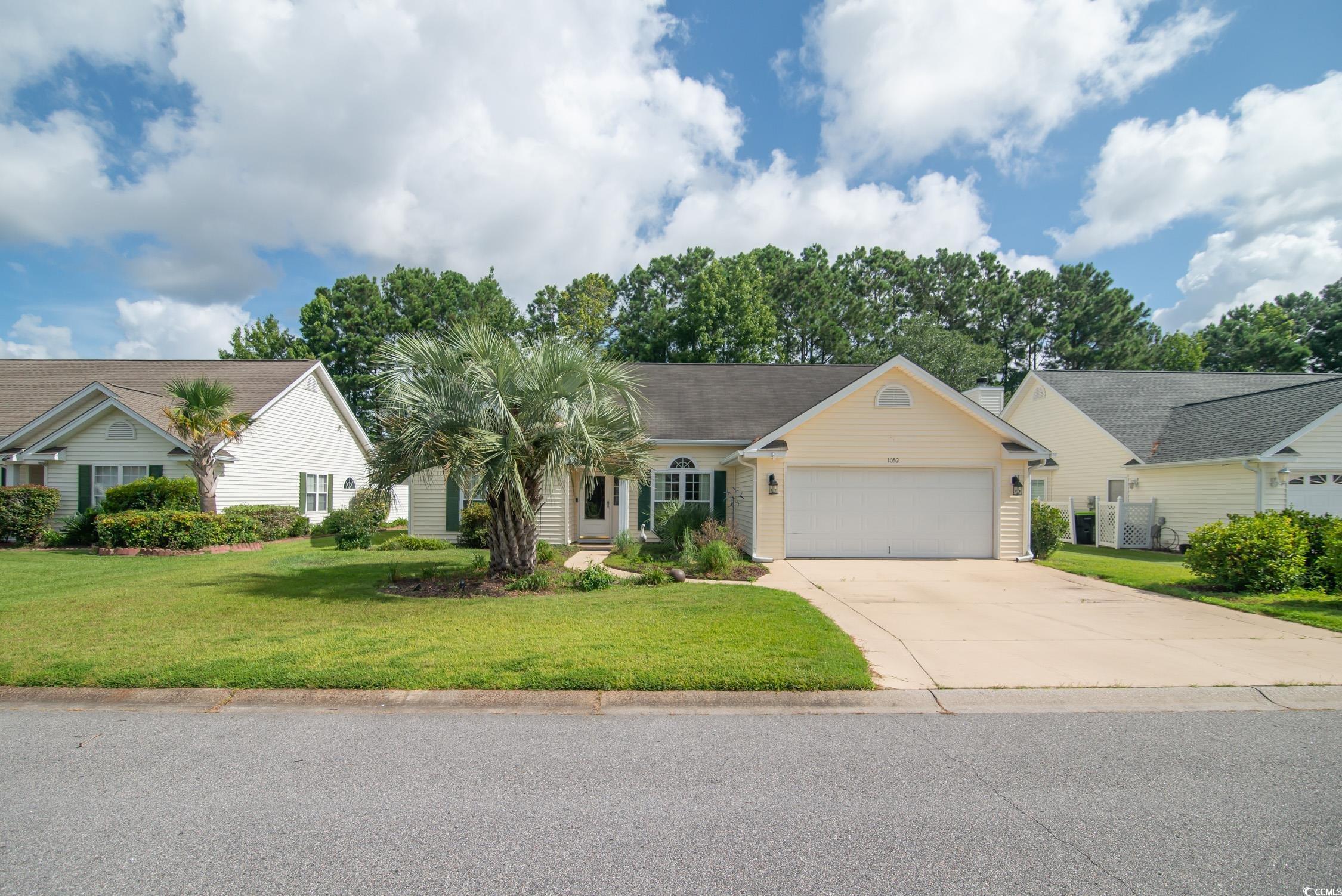 Ranch-style house with a garage, driveway, and a front yard