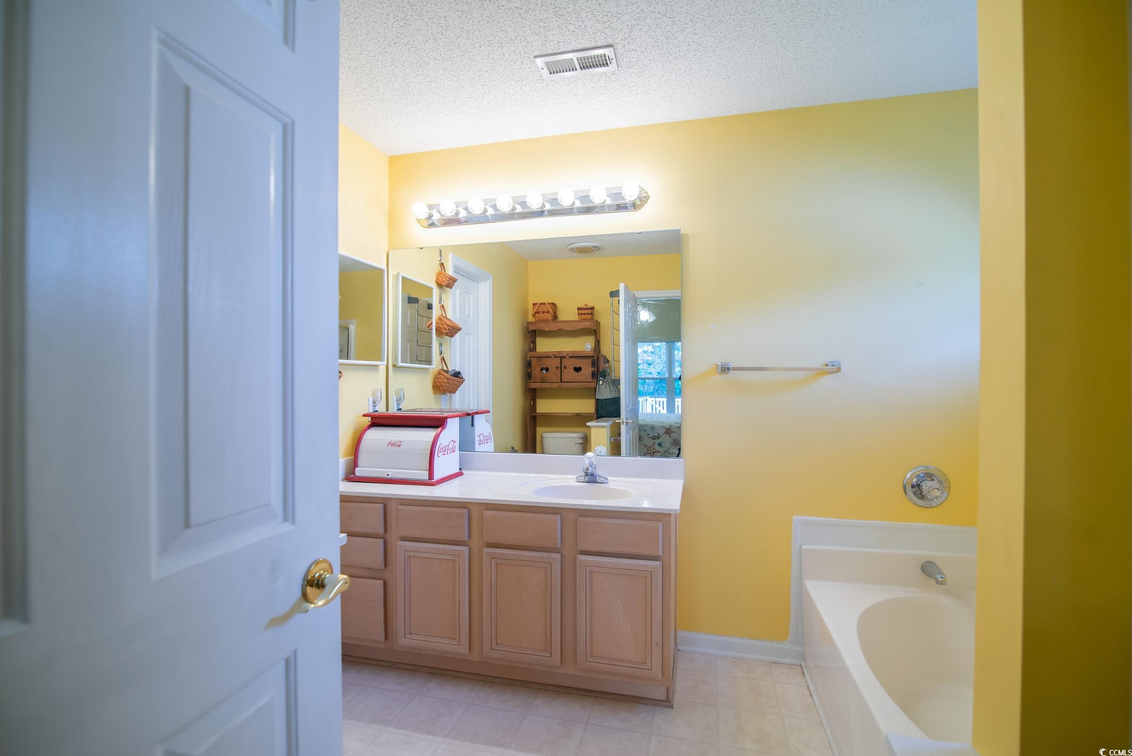 1052 Vestry Drive Murrells Inlet, SC 29576 - Photo 13 of 40 Full bathroom with a garden tub, vanity, tile patterned flooring, and a textured ceiling