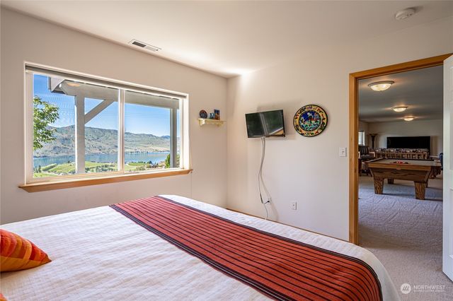 a living room with furniture a flat screen tv and a large window