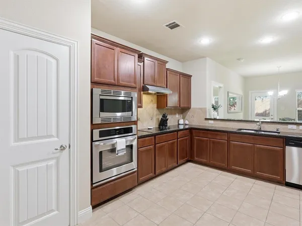 a kitchen with stainless steel appliances granite countertop a refrigerator and a sink