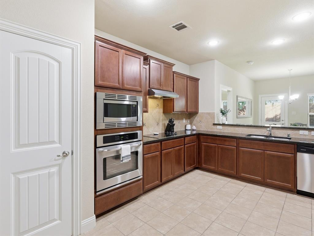 609 Racine Drive Oak Point, TX 75068 - Photo 5 of 30 a kitchen with stainless steel appliances granite countertop a refrigerator and a sink