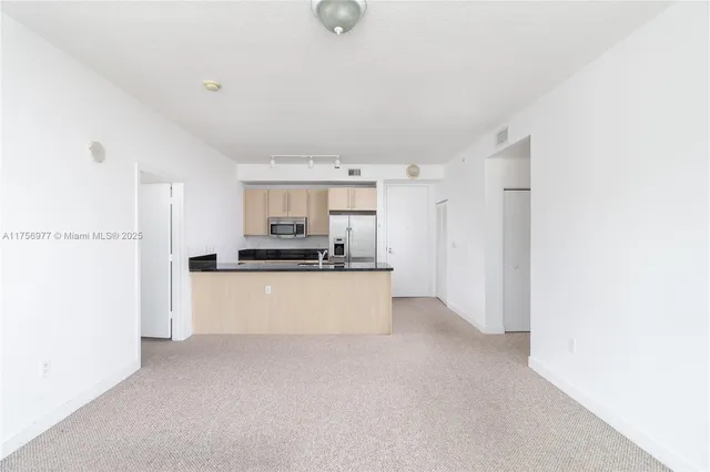 a view of kitchen with stainless steel appliances cabinets