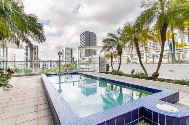 a view of swimming pool with outdoor seating and a palm tree