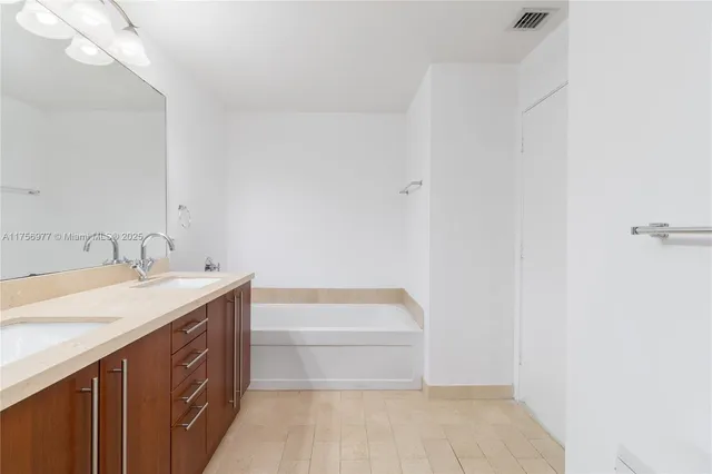 a bathroom with a sink a vanity and a bathtub