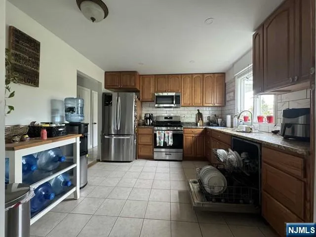 a kitchen with stainless steel appliances a stove a sink a microwave and cabinets