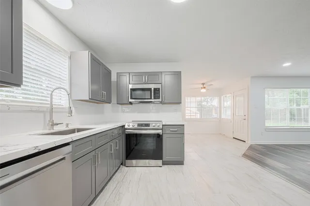 a kitchen with stainless steel appliances granite countertop a sink stove and refrigerator