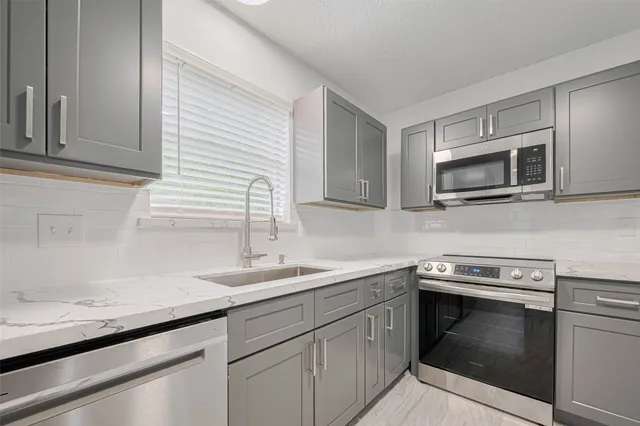 a kitchen with a sink stove and microwave
