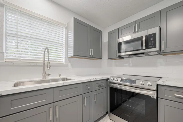 a kitchen with a sink stove and microwave
