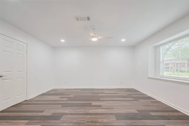 wooden floor in an empty room with a window