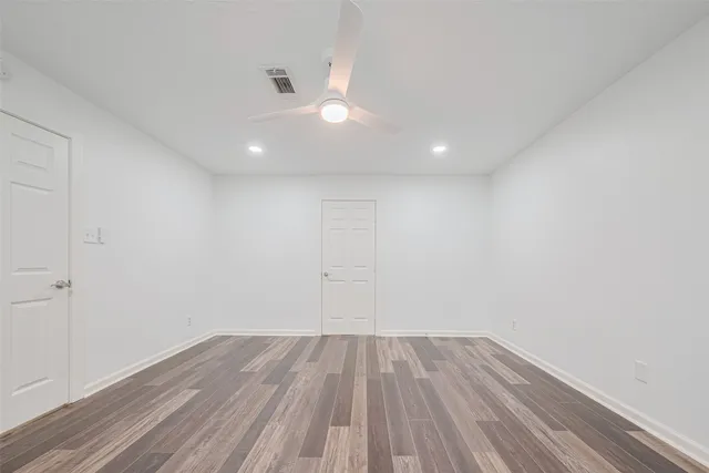 a view of a room with wooden floor and fan