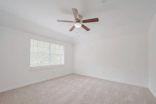 an empty room with a window and a fan