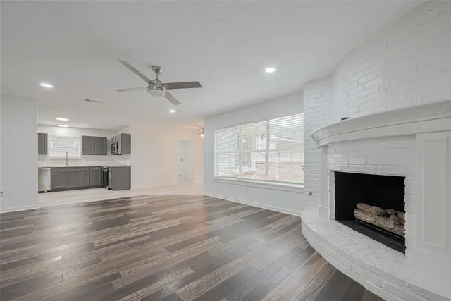 a view of an empty room with a fireplace and a window