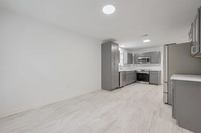 a view of a kitchen with a sink stove refrigerator and cabinets