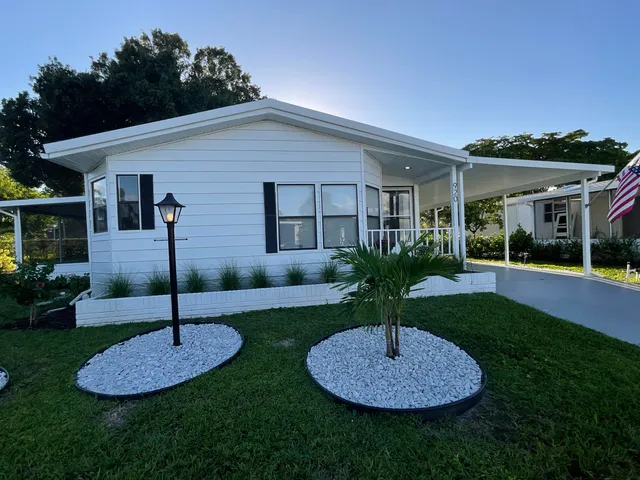 a front view of a house with a yard and green space