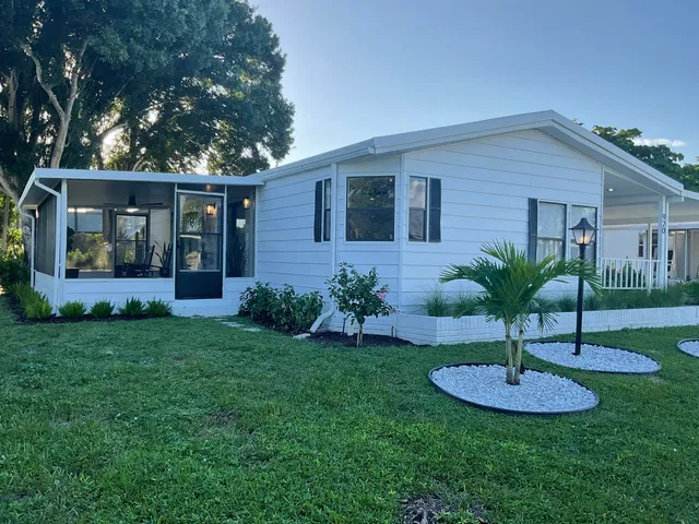 a view of a house with a yard patio and a tree