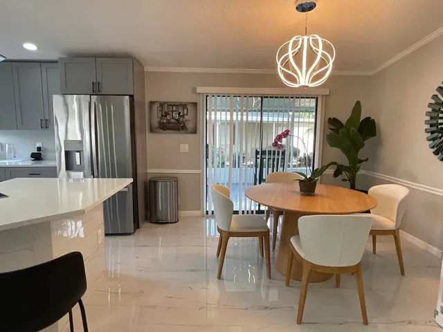 a dining room with furniture a chandelier and window