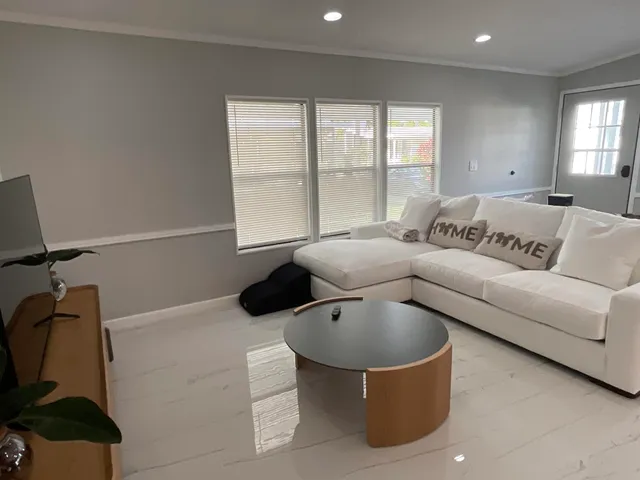 a utility room with stainless steel appliances wooden floor and large window