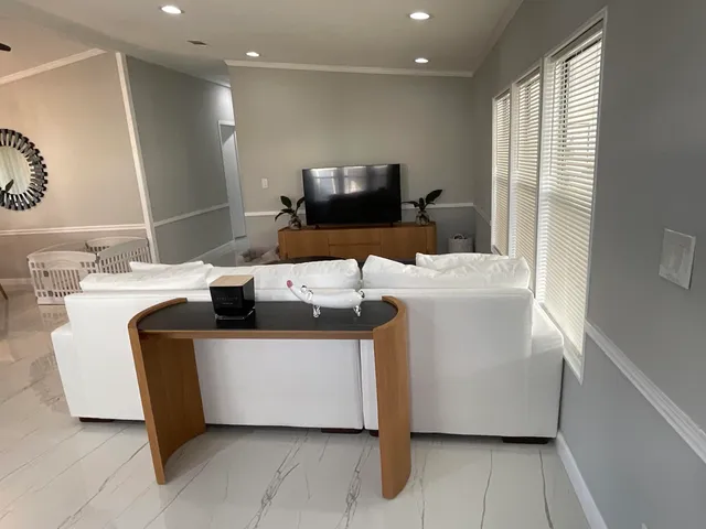 a large white kitchen with lots of counter space a sink and appliances