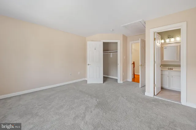an empty room with closet and a bathroom