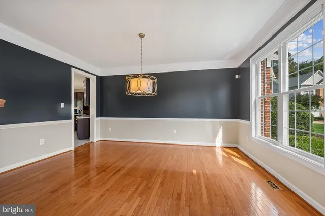 a view of a livingroom with wooden floor a ceiling fan and window