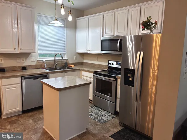 a kitchen with a sink stainless steel appliances and cabinets