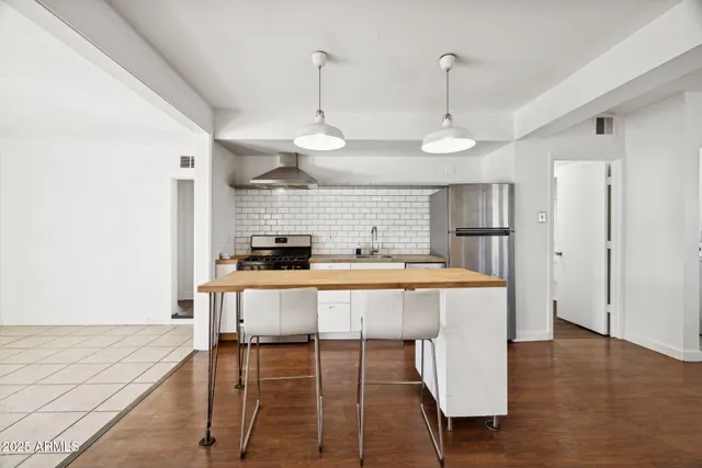a view of a kitchen with a sink stove and wooden floor