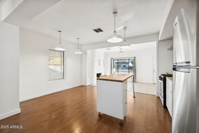 a view of a kitchen and a sink wooden floor windows