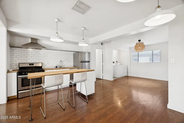 a kitchen with a stove and wooden floor