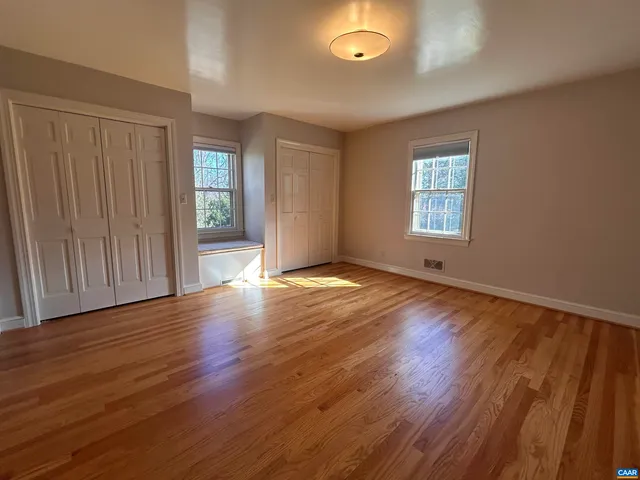 a view of an empty room with stairs and a window