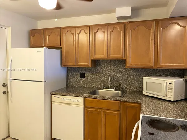 a kitchen with stainless steel appliances granite countertop cabinets and a refrigerator