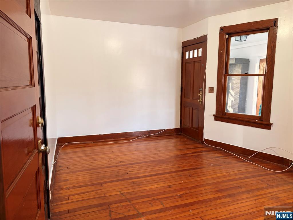 35 Marsellus Place, Unit 1 Garfield, NJ 07026 - Photo 15 of 37 a view of an empty room with wooden floor and a window