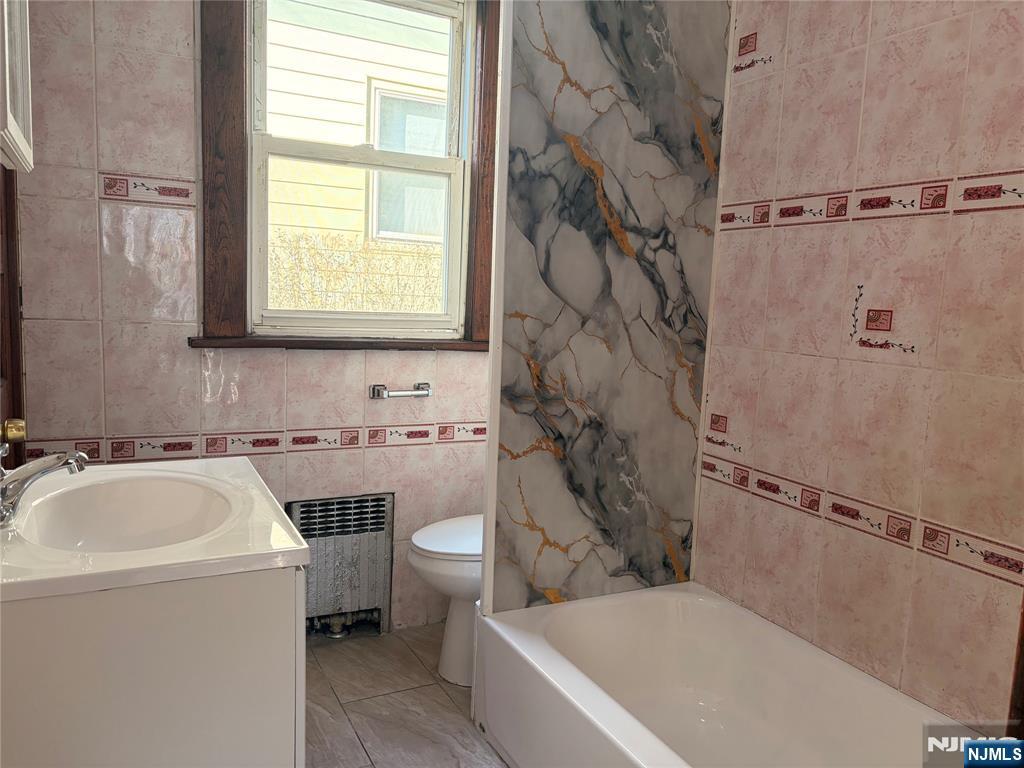 35 Marsellus Place, Unit 1 Garfield, NJ 07026 - Photo 21 of 37 a bathroom with a sink a toilet and a bathtub