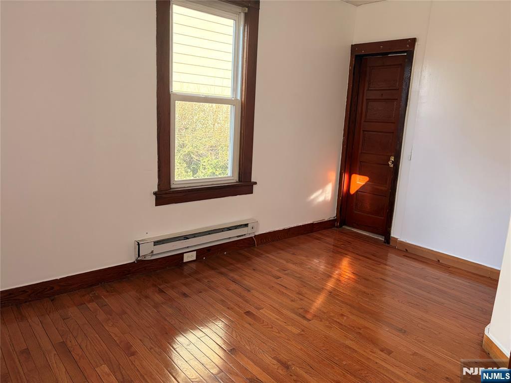35 Marsellus Place, Unit 1 Garfield, NJ 07026 - Photo 27 of 37 an empty room with wooden floor and windows